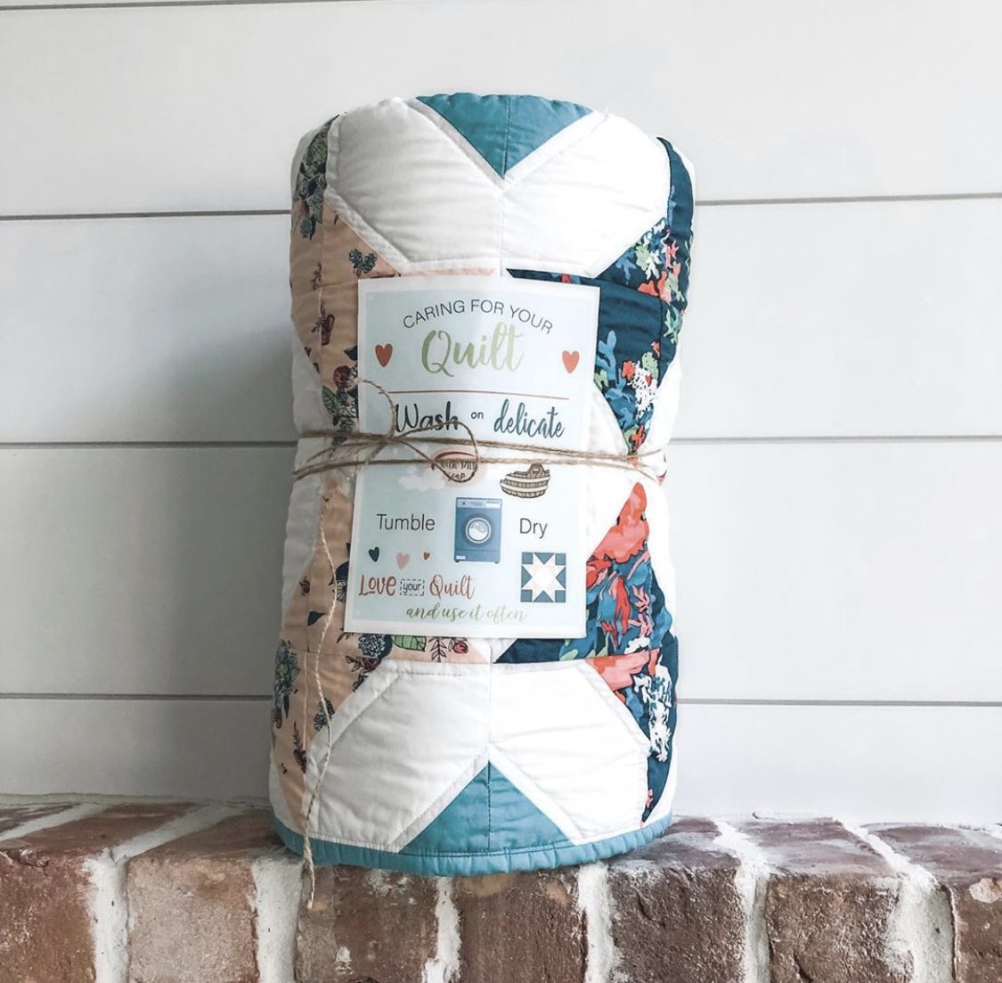 a quilt tied with ribbon with a Quilt Care Card