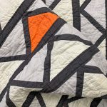 grey, black, and orange fabric triangles Cafe Tiles Quilt folded