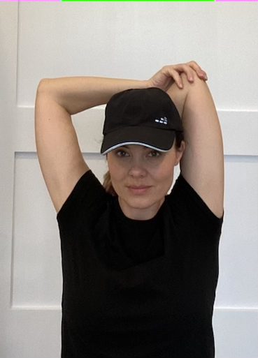 Elizabeth Chappell in a black hat and black shirt stretching her arms