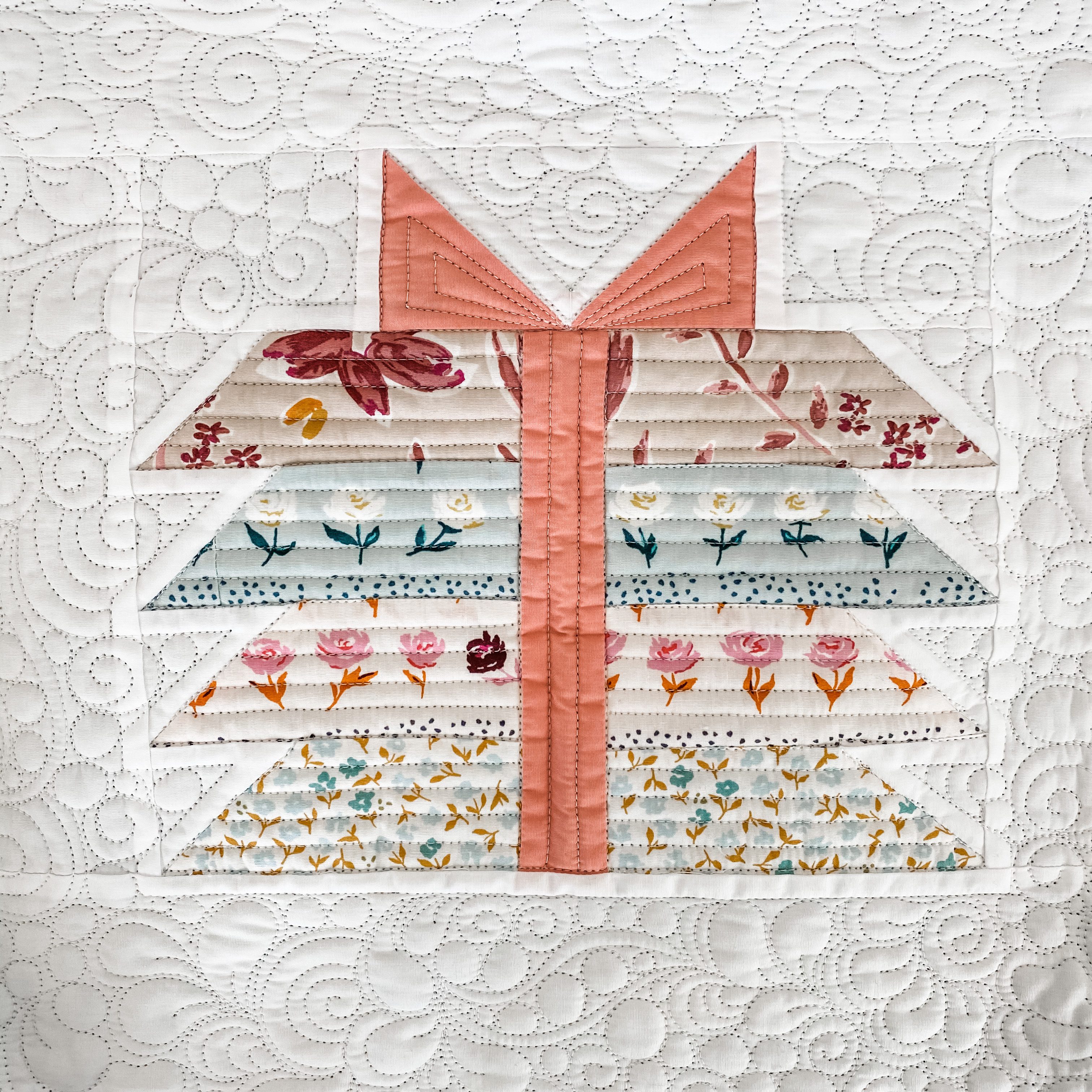 One 'Bundle Of Joy' Quilt block with a pink ribbon and blue and pink floral fabric.