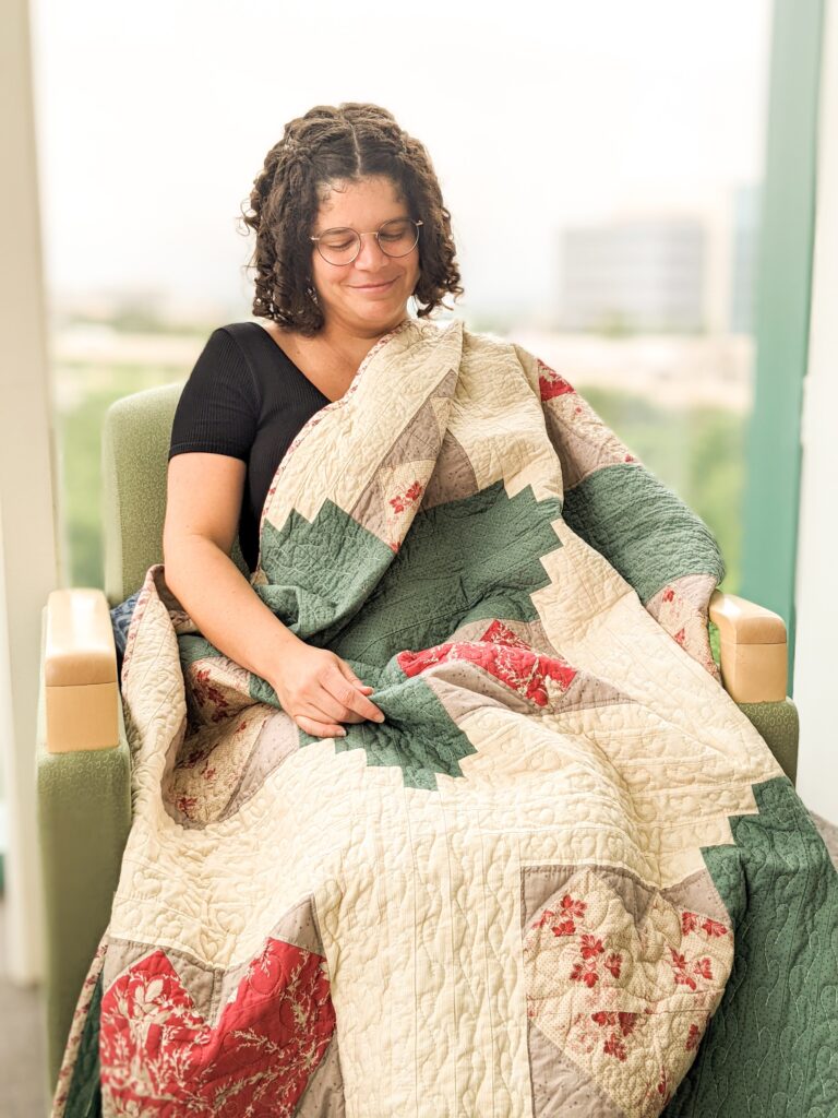 Lauren Metang evaluating with quilt draped across her lap.
