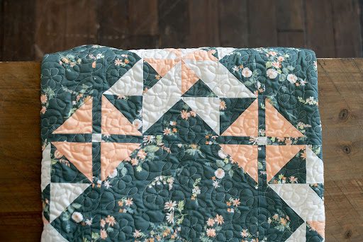 Peach and Teal quilt with flower long arm quilting