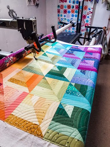 Rainbow colored quilt with The Baptist Fan quilting design