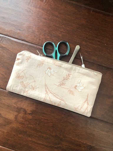 opened zipper pouch with quilting scissors and seam ripper