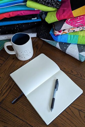 fabrics (projects) with coffee and notebook