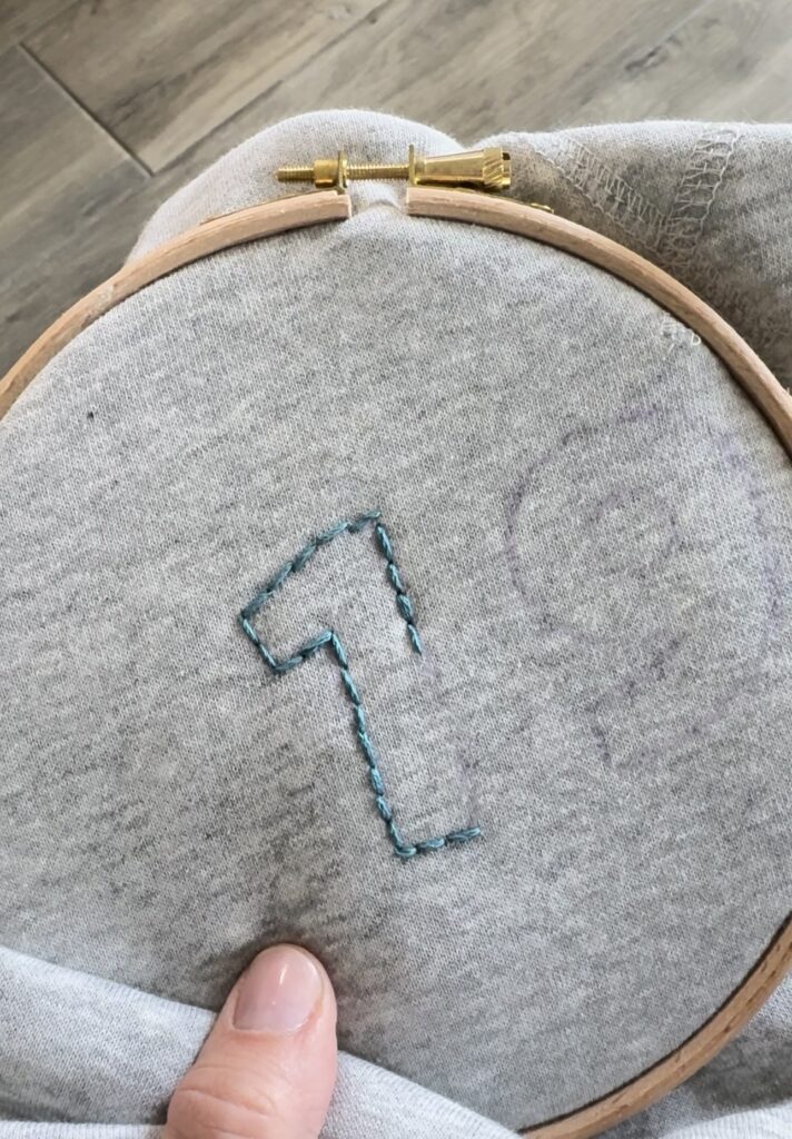 number one outlined with blue embroidery floss