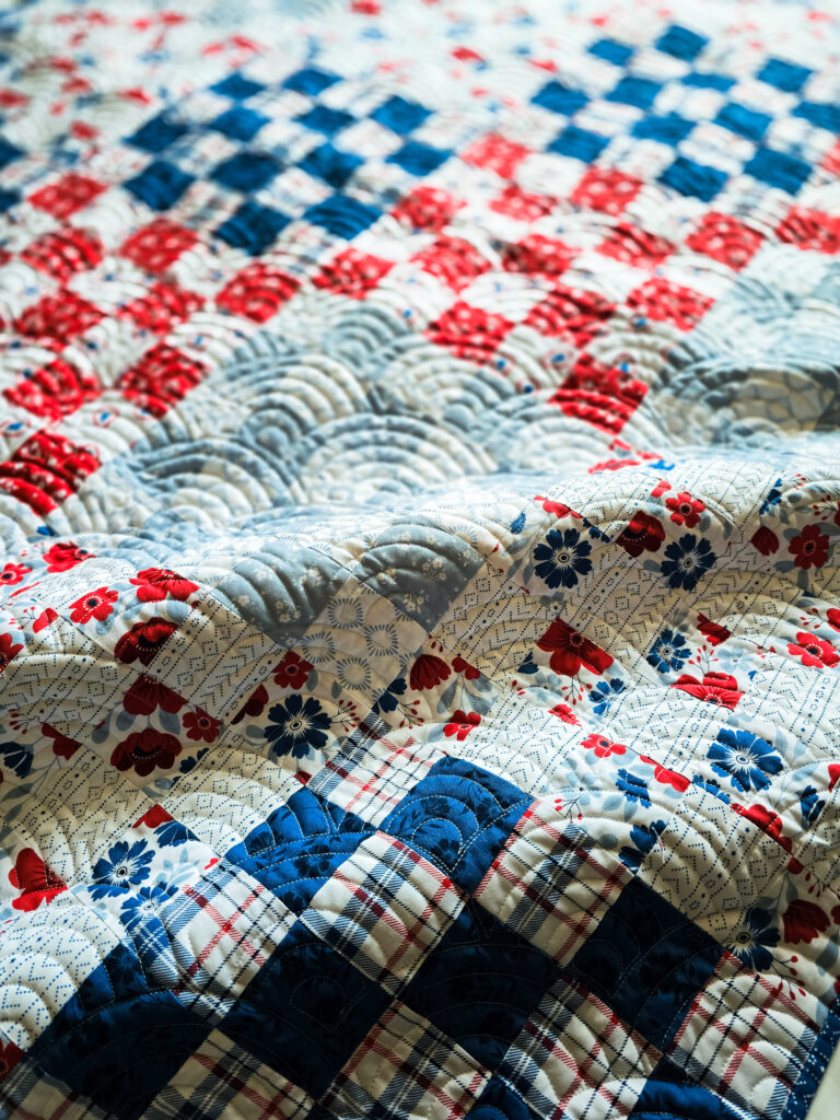 Close-up of Baptist Fan pantograph quilting showing texture and movement on a traditional quilt