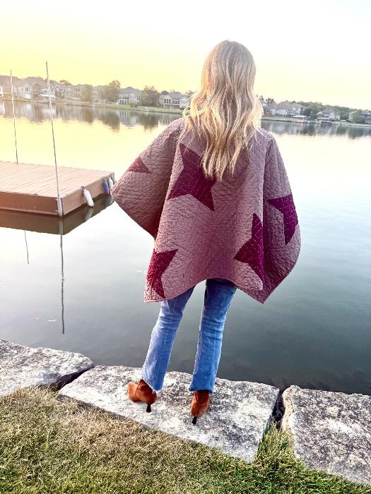 Back view of a handmade quilted ruana with burgundy star blocks and a loose draped fit