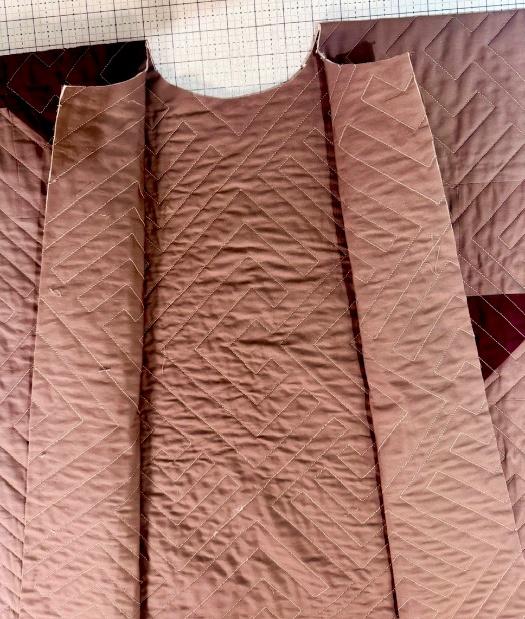Back view of a handmade quilted ruana with burgundy star blocks and a loose draped fit