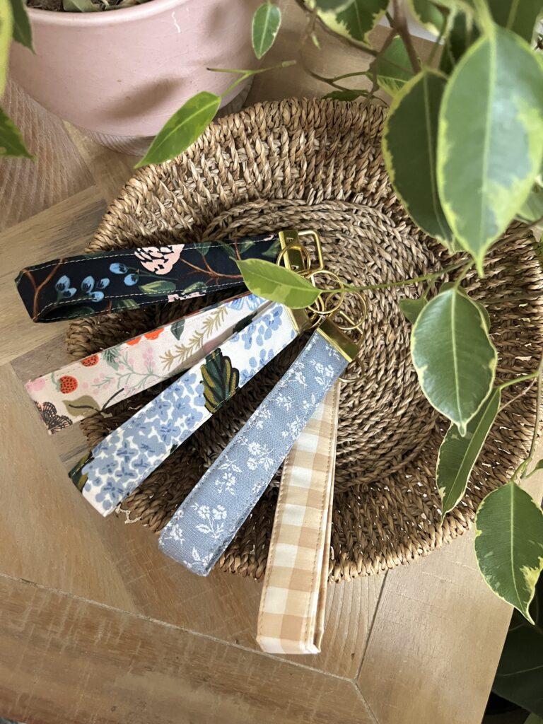 Scrap fabric key fob wristlets in a seagrass basket with a green plant