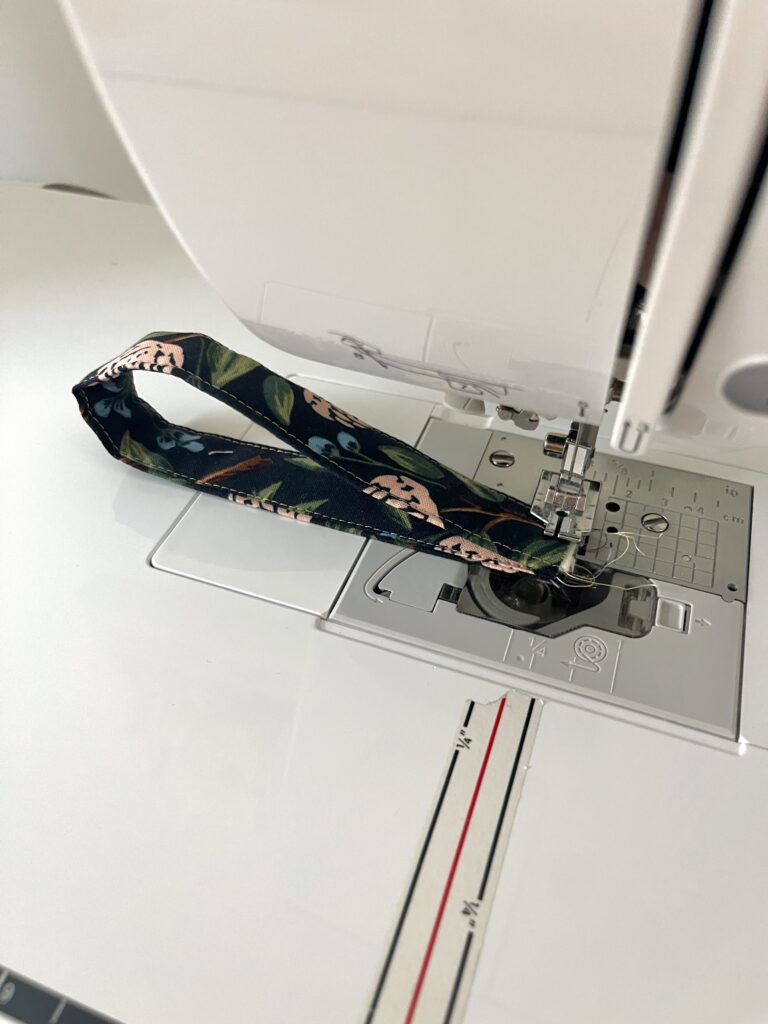 Short ends of a fabric key fob strap sewn together with a 1/4 inch seam on a sewing machine