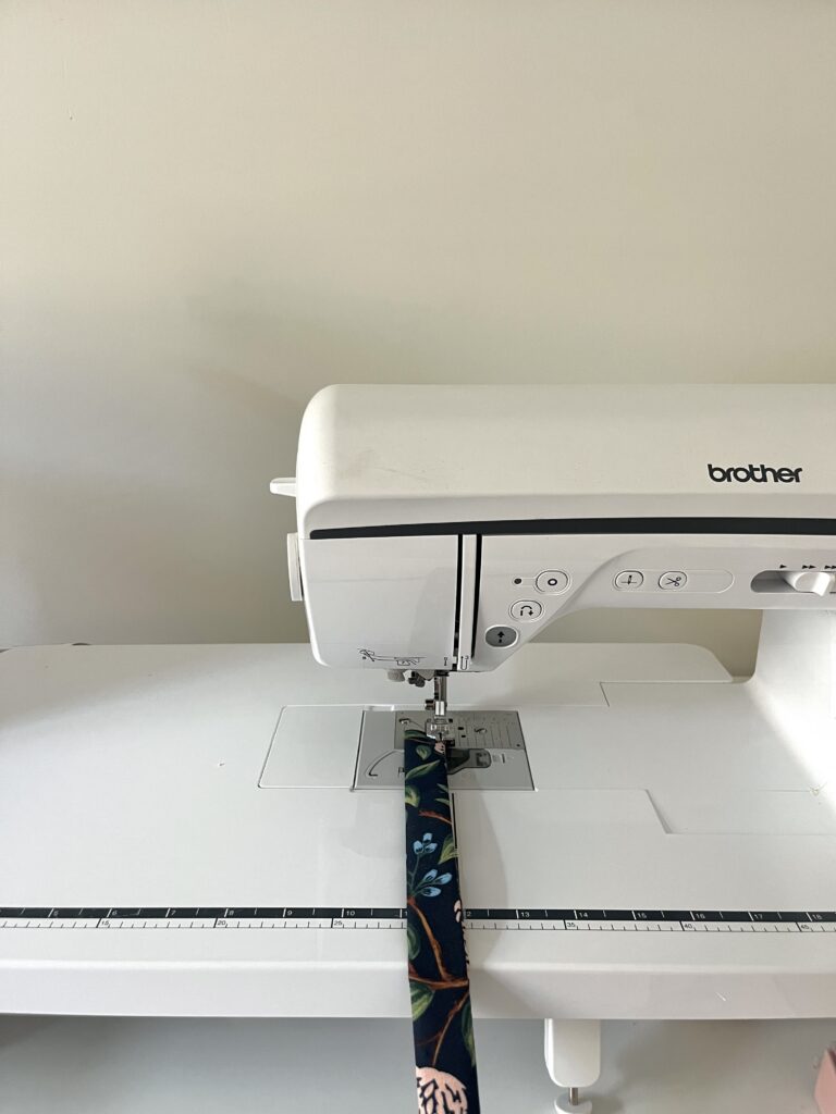 Topstitching the long edges of a floral key fob wristlet strap on a Brother sewing machine